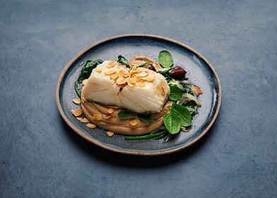 Bacalhau da Noruega confitado com purê de castanhas e cebolada de espinafres
